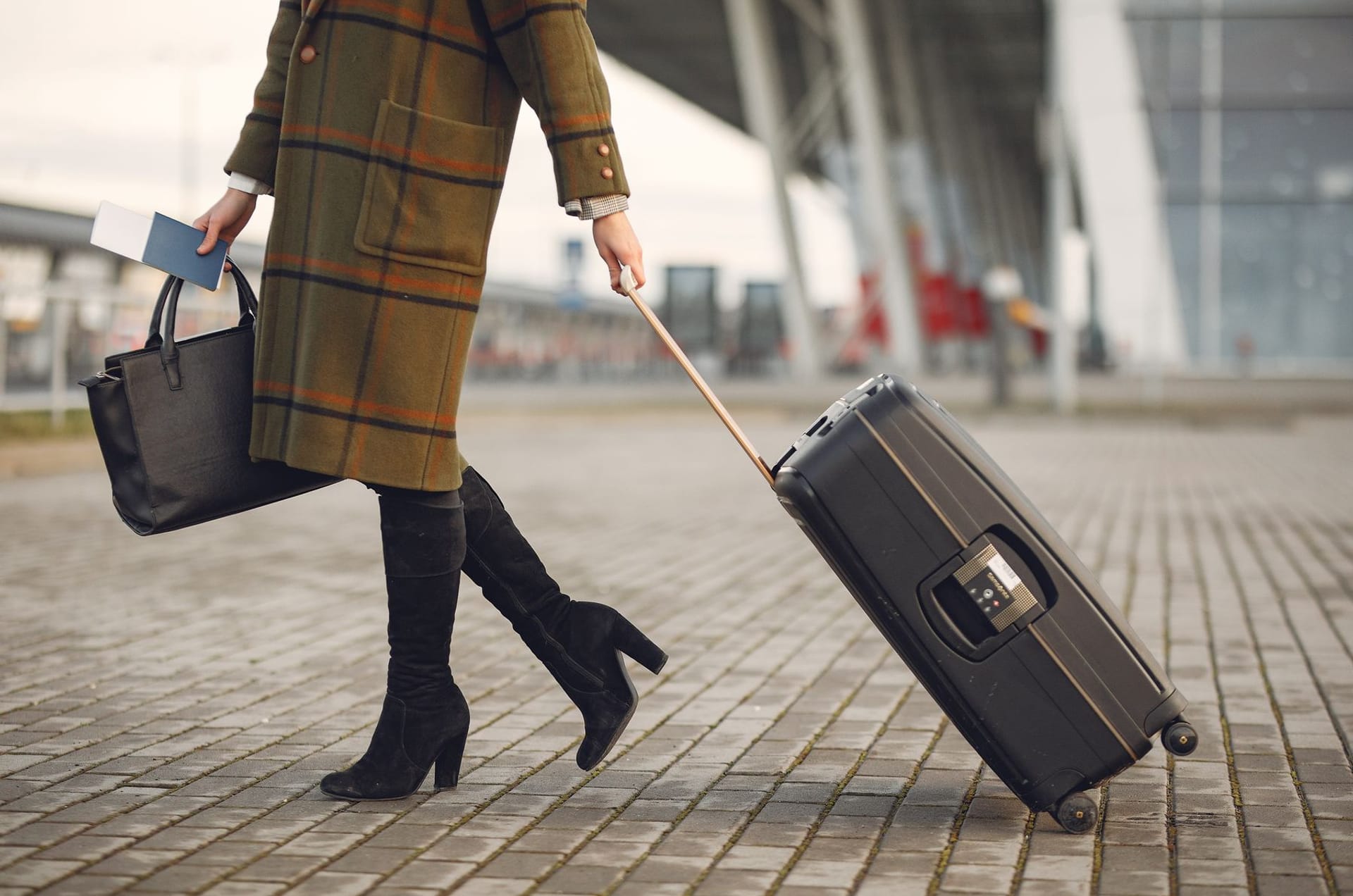 A traveller walking with a suitcase outside the terminal